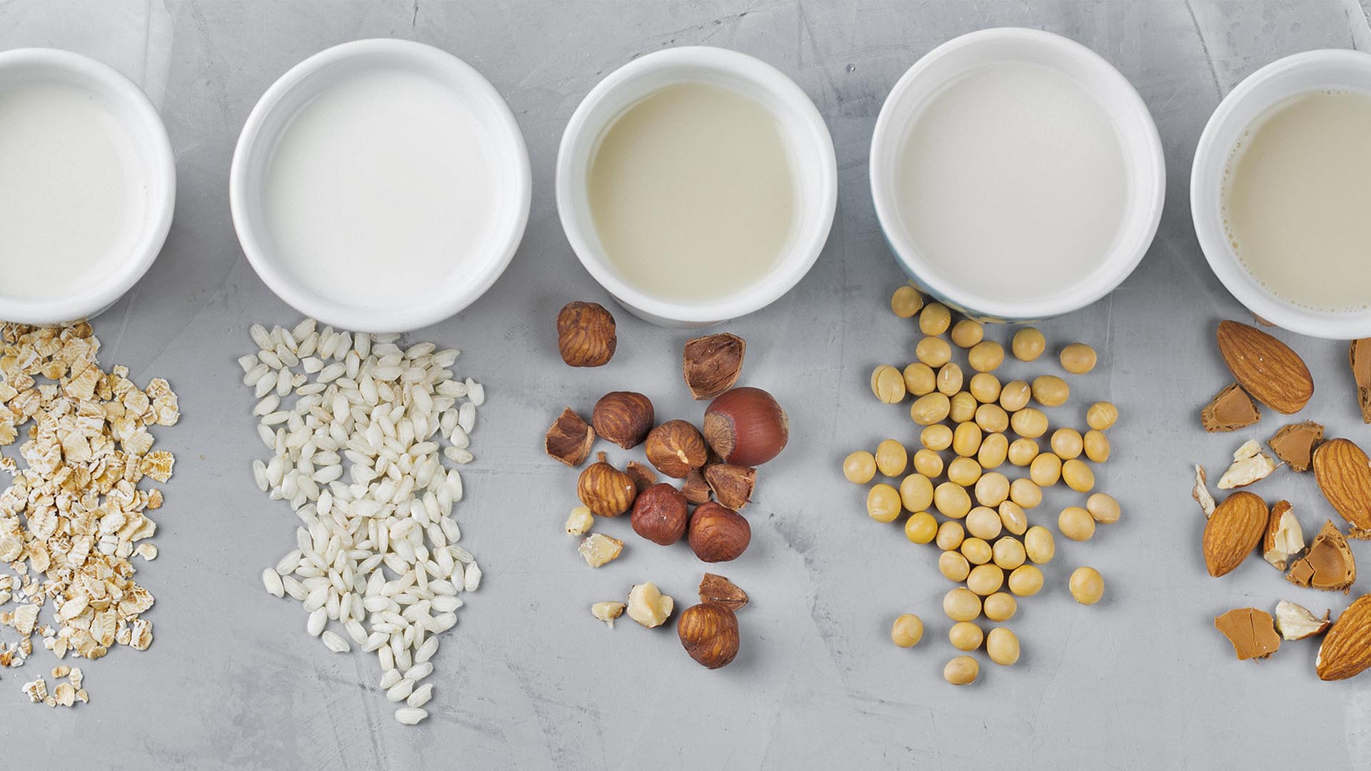 Flat lay at Non-dairy alternatives Soy milk or yogurt in mason jar and tofu on white wooden table with soybeans in bowl aside